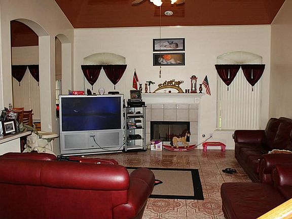 Large living room with fireplace and windows flaking fireplace. Custom ceiling throughout downstairs