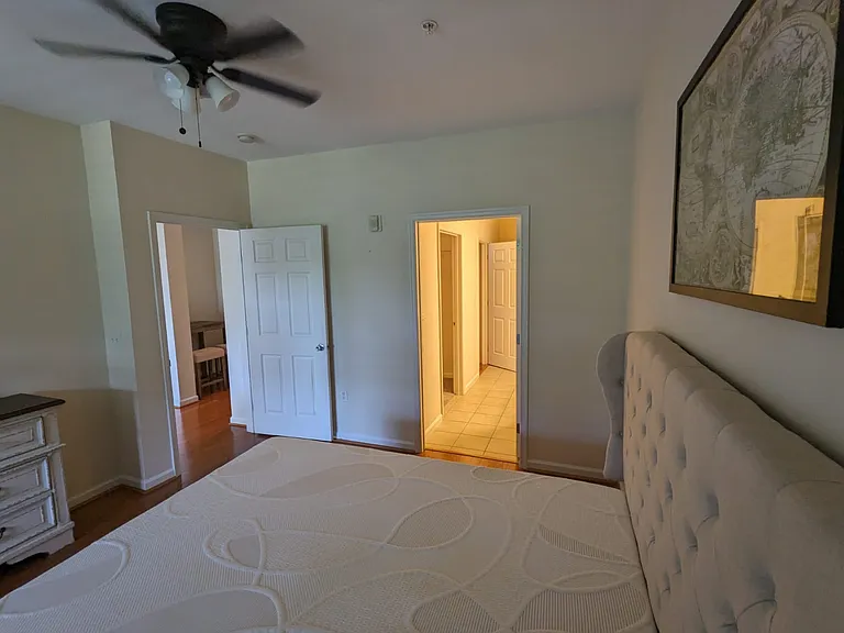 Master bedroom furnished with a king-size bed and a dresser with a mirror