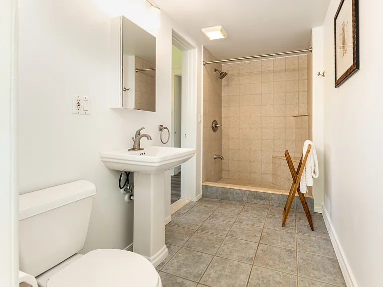 Ensuite bathroom featuring a walk-in shower and convenient exterior access to the yard_ideal after a day at the beach.