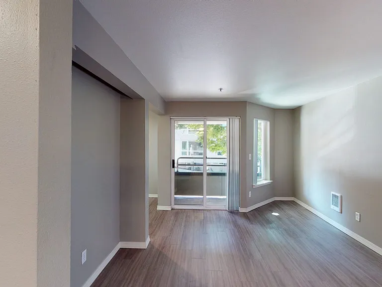 Apartment living room with wood-style flooring or plush carpet flooring and balcony.