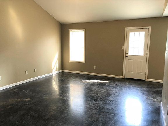 Large living room with tall ceilings and natural light.