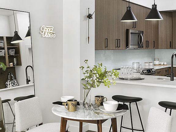 Apartment Kitchen with Stainless Steel Appliances, quartz countertop and hardwood flooring.