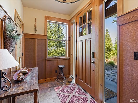 The entry with slate flooring, solid wood doors & millwork and wood wainscoting.