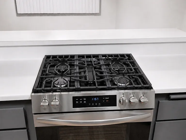 Newer stainless steel gas range with modern controls and multiple burners.