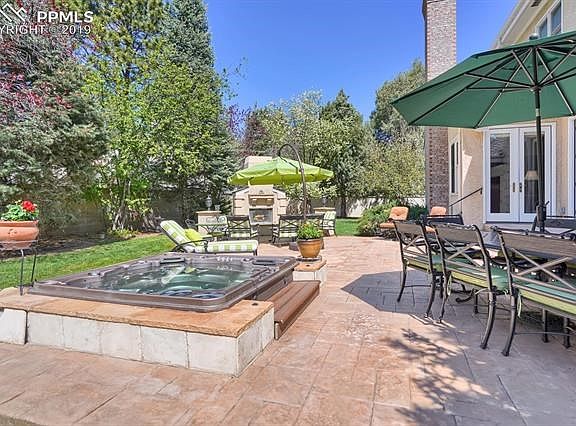 Large patio with newer built in hot tub adjoins the kitchen and family room (3 sets of french doors)