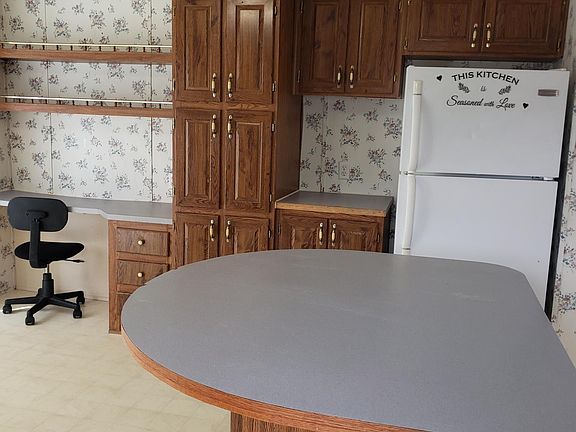 Kitchen showing built in desk, and refrigerator and more cabinets