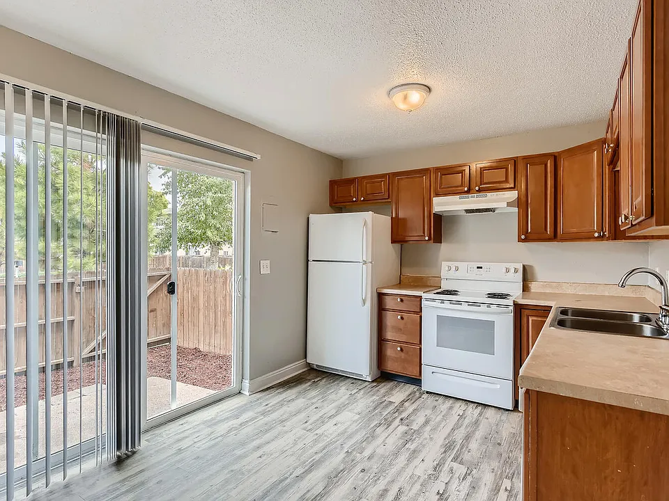 A kitchen with a Sliding Door, Refrigerator and Range oven at Alder Square Rental Townhomes