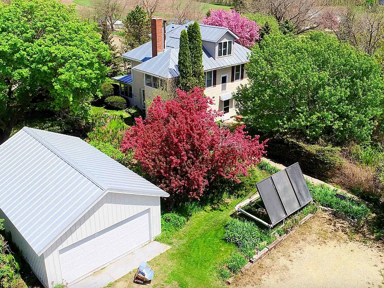 exterior of farmhouse and detached 2-car garage with electric vehicle recharging connectors