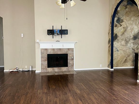 Living room with ceiling fan and fireplace