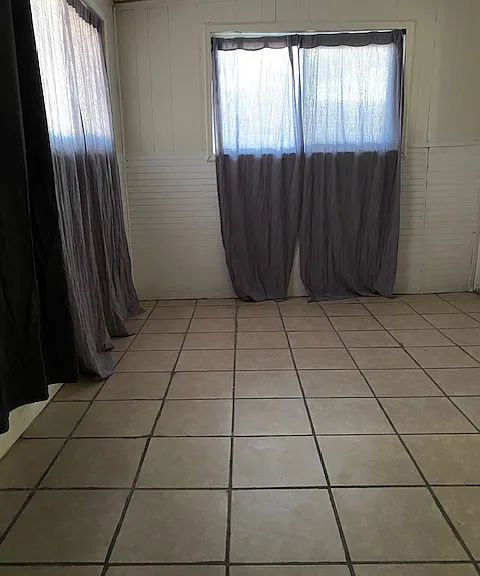 View of enclosed back porch. Cloth curtains are no longer there. No window coverings are there now,
