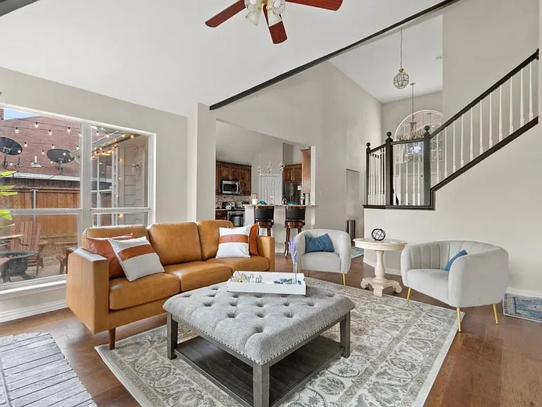 Living room with designer furnishings and curated art features a 65 inch 4K smart TV with Roku.