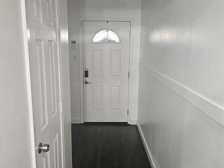 Doorway featuring wood finished floors and baseboards