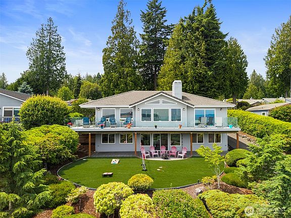 Huge windows extend across the back of the house to catch those fabulous views and bring them inside! The park-like yard is framed by lovely native landscaping, making it a perfect place to gather.>