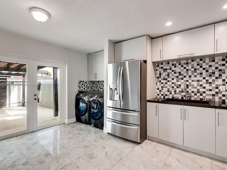 The kitchen area ( apx 14' X 12' ) and was installed apx in 2018 and has all SS LG appliances plus the washer/dryer. New Impact glass French Doors lead out to the covered patio. Notice that the wood beams that hold the canvas top to the shaded area of the