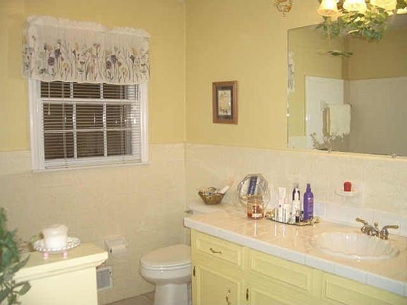 White tile surrounds the jetted tub in this updated  bathroom.