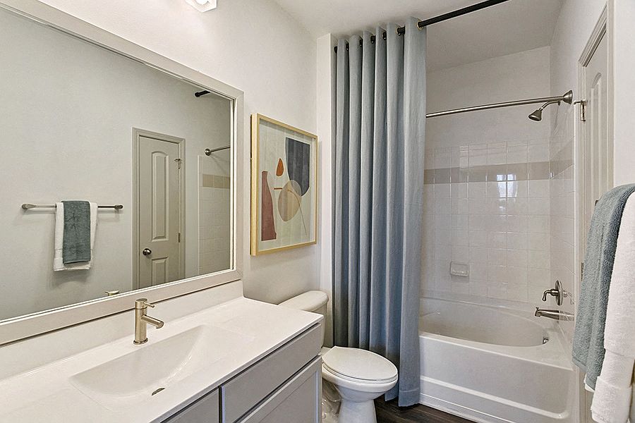 Bathroom upgrades include luxury vinyl plank flooring, framed mirrors and brushed nickel hardware
