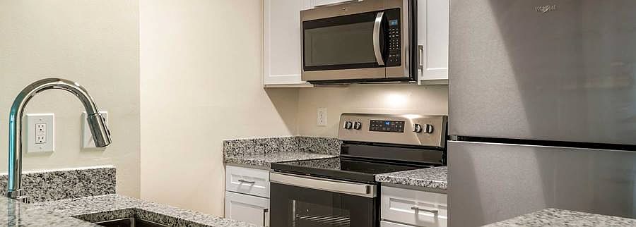 Finish Package IV kitchen with granite countertops, white cabinetry and stainless steel appliances