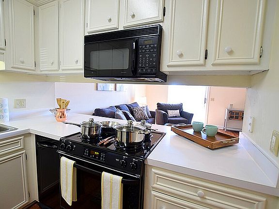 Experience the charm of this cozy kitchen seamlessly flowing into a welcoming living room.