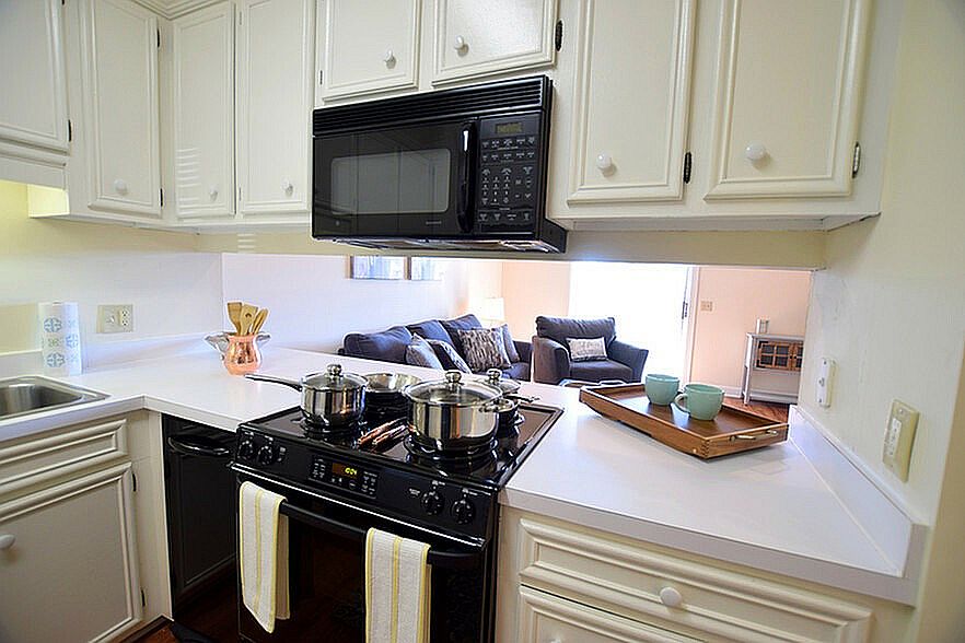 Experience the charm of this cozy kitchen seamlessly flowing into a welcoming living room.