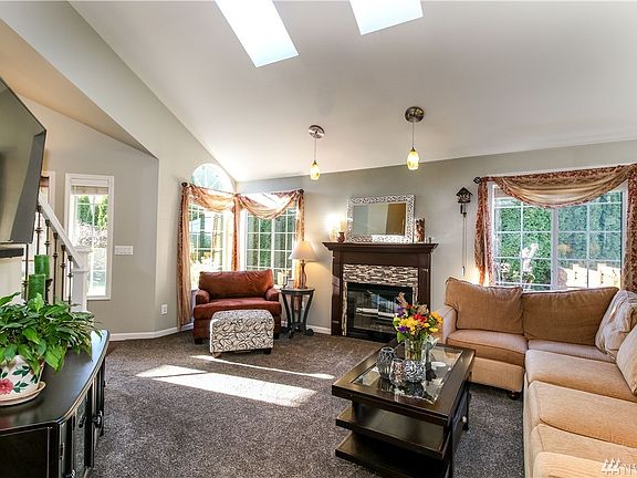 The living room is brightened by natural light flowing in through skylights.