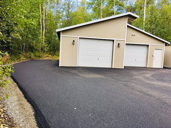 Oversized two-bay garage with side parking pad
