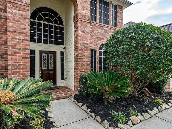 A flagstone lined walkways leads you to an arched brick front porch that beckons you to enter the home!
