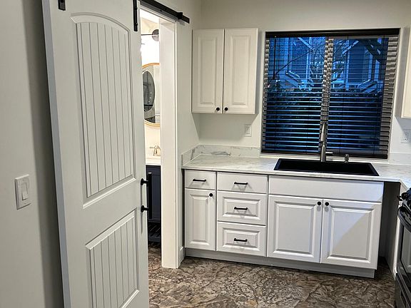 Door opened off of the kitchen gives glimpse of bathroom, washer/dryer, and closet area.