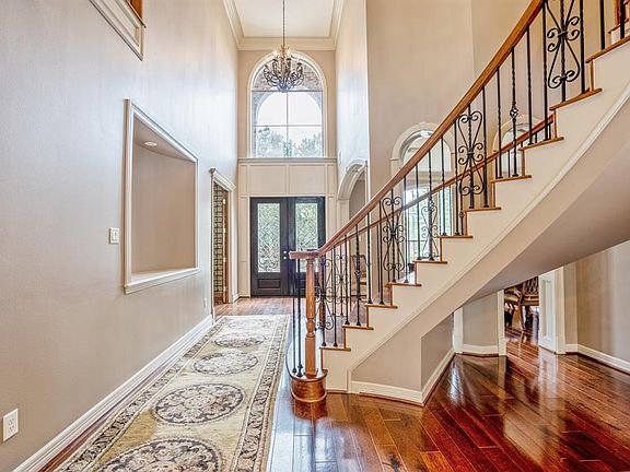 The formal entry features 2 story ceiling and sweeping staircase with wrought iron spindles and wooden stairs. This space is flanked by the formal dining room and a study /library.