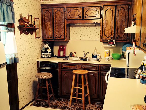 Kitchen area with a ceramic cook top stove and kitchen vent above. Door to the left goes to the covered patio. 