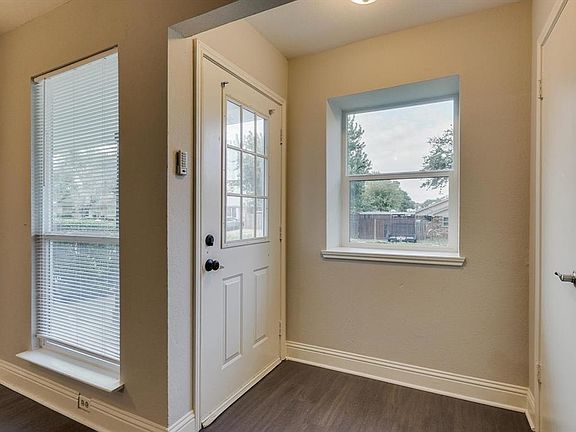 Doorway to outside with baseboards and dark wood-style flooring