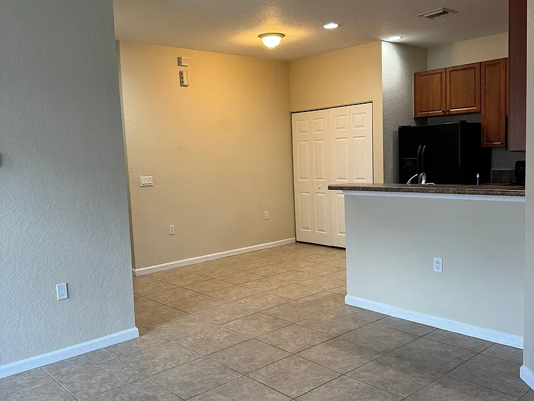 The spacious kitchen has an eat at high bar, double door refrigerator, microwave oven, stove and dishwasher. Bi-fold doors cover the laundry nook.