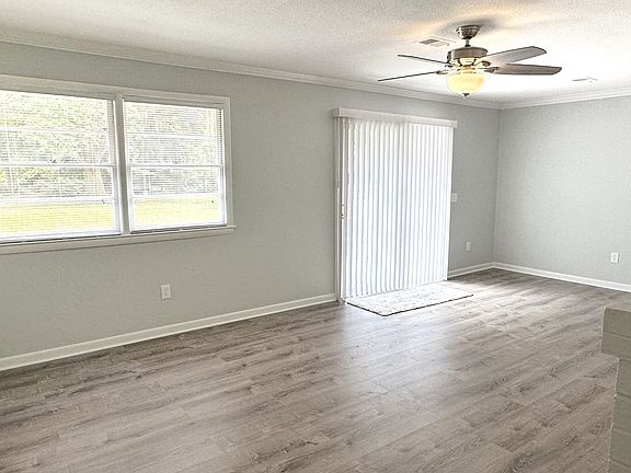 Family room with double window and sliding glass door. New Flooring and has been recently painted.