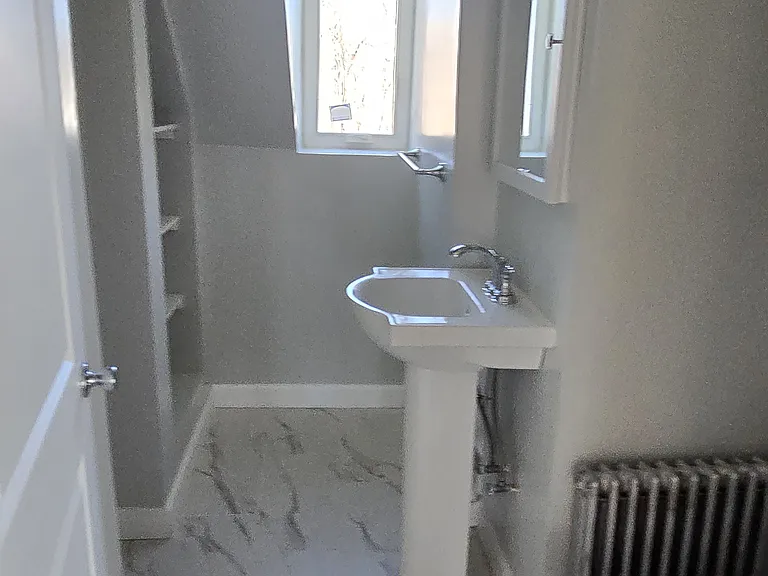 Bathroom area with shelves space for additional storage. Stand up shower.