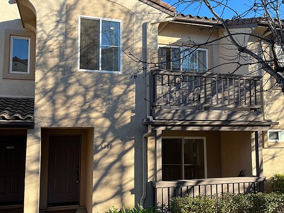 Front exterior of townhouse featuring both balconies and lots of windows for natural light