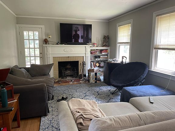 living room with wood-burning fireplace, built in shelves and french door access to screened porch