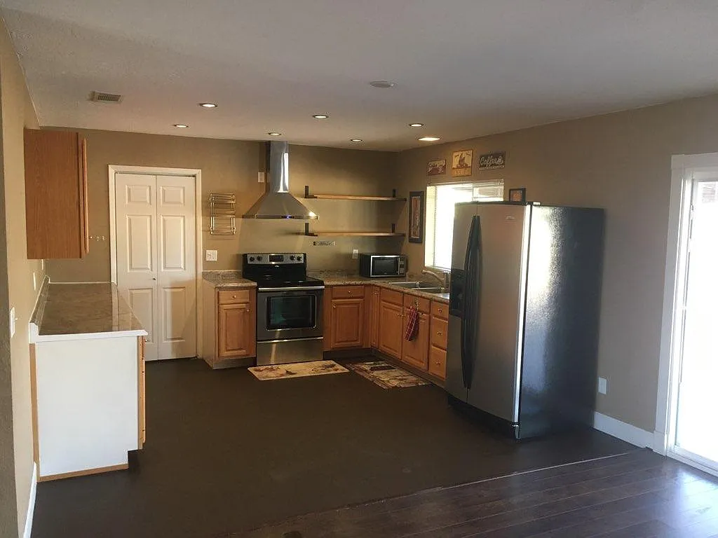Kitchen with stainless steel fridge, oven and vent hood. - 2226 W Oraibi Dr