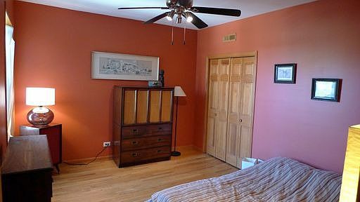 Large master bedroom with ceiling fan for comfort.