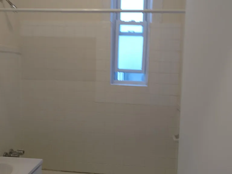 Tiled bath with deep soaking tub.and privacy window.