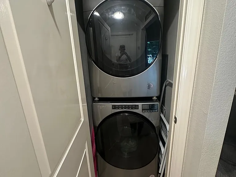 laundry room with stackable washer and dryer. 3 year new