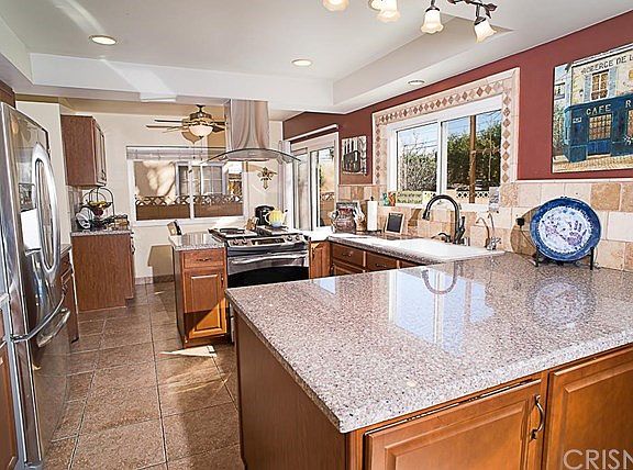 The kitchen offers a sunny breakfast nook with ceiling fan and sliding door to the backyard patio.