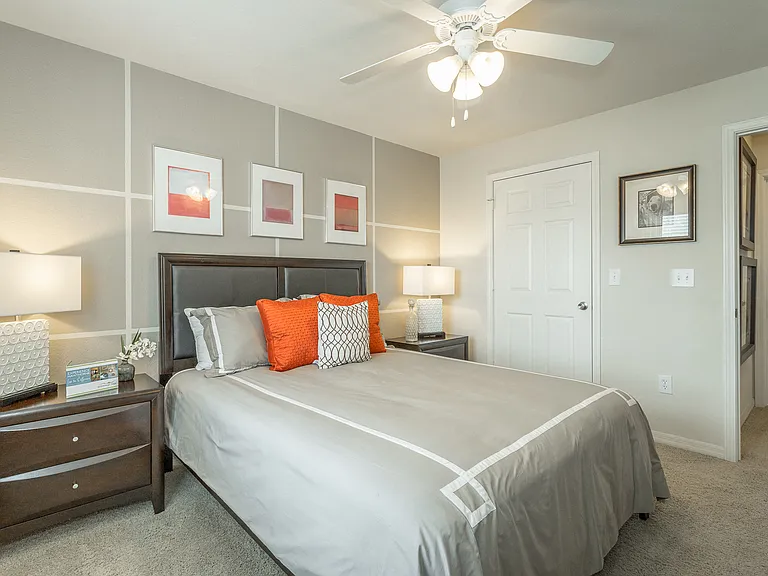 Spacious bedroom with plush carpeting and ceiling fan with lighting