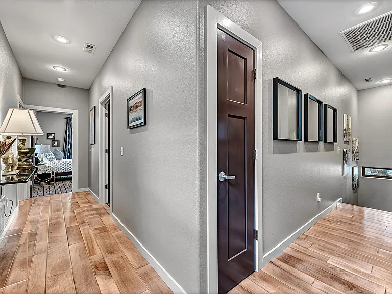 Standing in the doorway of the primary suite to the right you have the stairs and to the left you have the two guest rooms and bathroom.