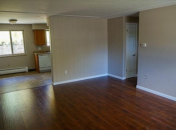 View from front door through living room to dining nook next to kitchen.