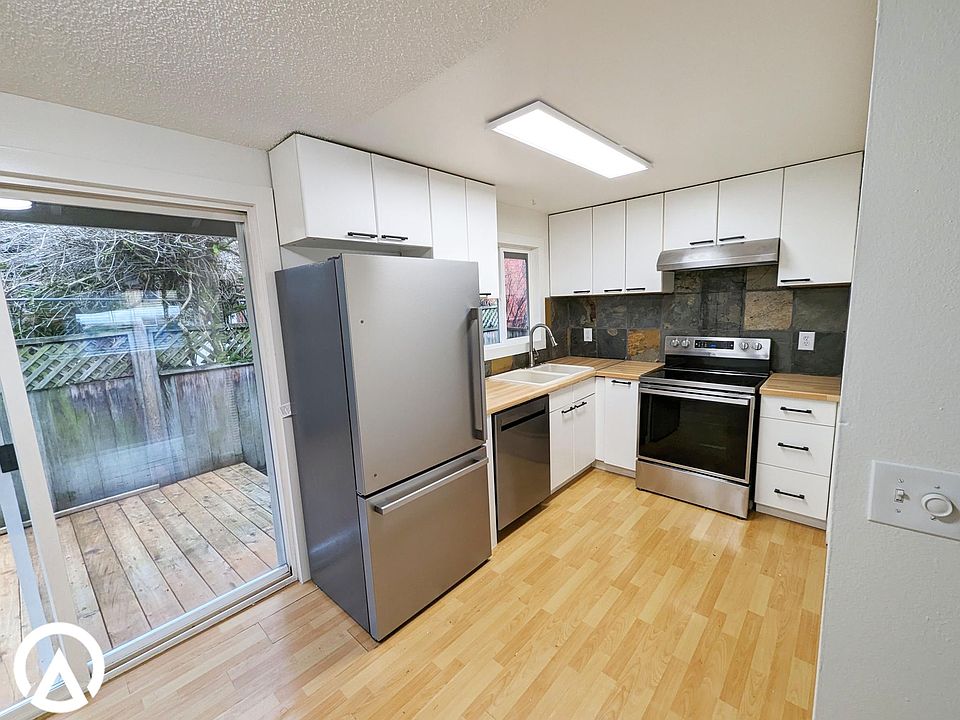 Bright, white, IKEA kitchen with brand-new stainless steel appliances including dishwasher. Slider with access to private, fenced back deck.