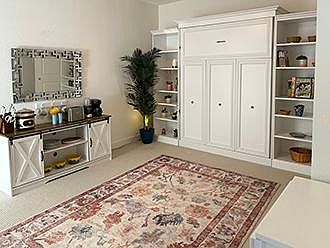View of the Murphy bed as it's folded up leaving a very spacious living space. 
The kitchenette is on the left.