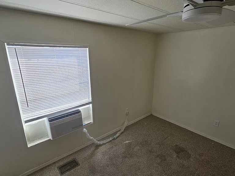 The photo shows the previous flooring before upgrades; the home now features freshly installed LVP that gives the space a clean, modern feel. A mini_split system is also in place in the upper right corner.