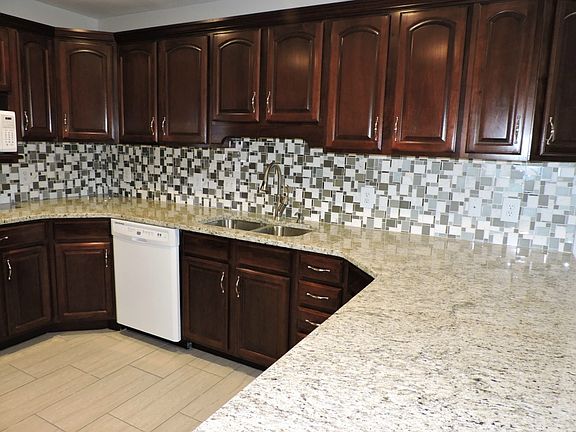 Granite counters with mosaic glass tile backsplash.