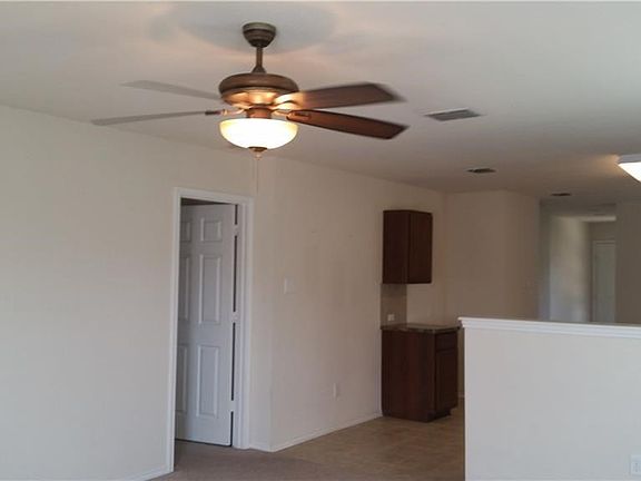 A view of the kitchen taken from the family room. The family room has upgraded carpet and an upgraded ceiling fan. There is a half wall between the family room and the breakfast room.