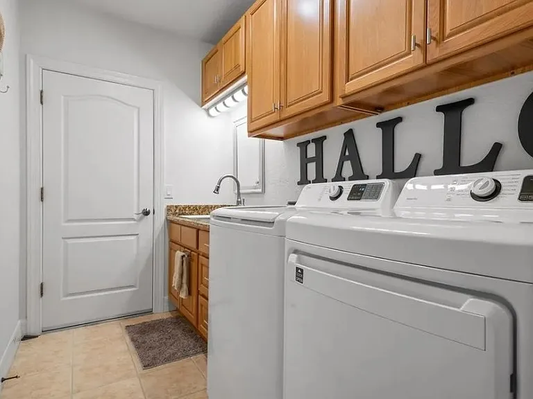 Full laundry and storage with sink with door to garage