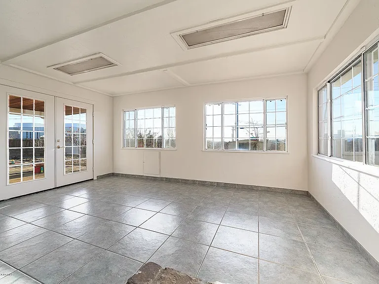 The large, open windows overlook the landscaped backyard, filling the space with abundant natural light and beautiful views.